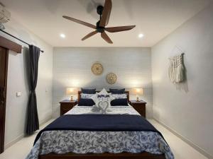 a bedroom with a bed with a ceiling fan at Bali Santi Bungalows in Candidasa