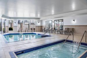 una piscina con sedie e tavoli in un edificio di Courtyard by Marriott Edmonton West a Edmonton