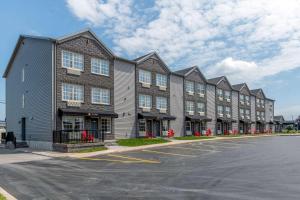 eine Reihe von Apartmenthäusern auf einem Parkplatz in der Unterkunft Quality Inn & Suites Amsterdam in Fredericton