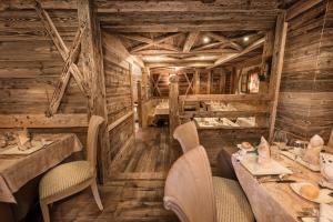 um restaurante com paredes e mesas e cadeiras de madeira em Sporthotel Romantic Plaza em Madonna di Campiglio