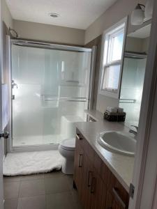 y baño con ducha, aseo y lavamanos. en Cozy 3 Bedroom home, en Spruce Grove