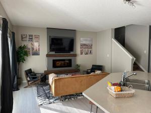 sala de estar con sofá y chimenea en Cozy 3 Bedroom home, en Spruce Grove