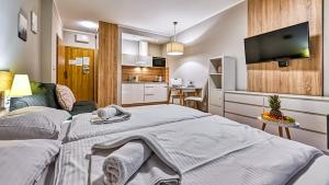 two beds in a small room with a kitchen at Apartamenty Sun & Snow Resort Karkonosze in Szklarska Poręba