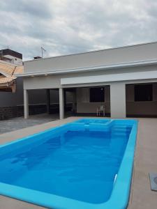 una gran piscina azul frente a un edificio en Casa 50m do mar, en Matinhos