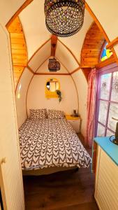 Downtown Tiny houses near Cismigiu Gardens في بوخارست: غرفة نوم بسرير في غرفة صغيرة