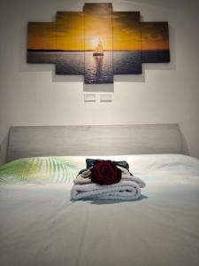 una camera da letto con un letto con una rosa sopra di La dimora sul lido ad Alghero