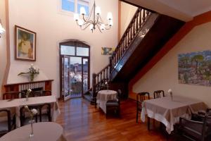 a dining room with tables and chairs and a staircase at Hotel Colonial Salta in Salta