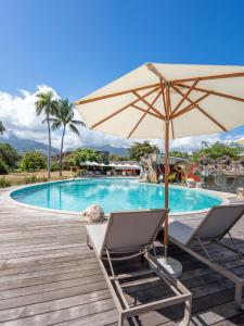 a pair of chairs and an umbrella next to a swimming pool at Royal Tahitien in Papeete