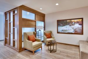 a living room with two chairs and a painting on the wall at Fairfield Inn & Suites by Marriott Denver West/Federal Center in Lakewood