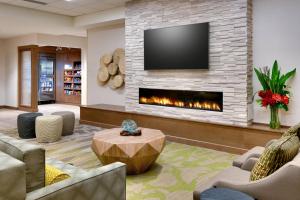 a living room with a fireplace and a tv at Fairfield Inn & Suites by Marriott Denver West/Federal Center in Lakewood