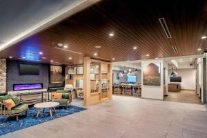 Fairfield Inn & Suites Fort Worth Northeast في هورست: لوبي مع مكتبة مع كراسي وطاولة