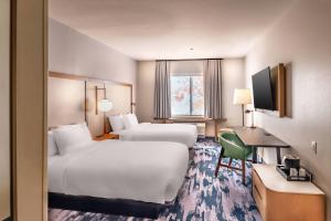 Fairfield Inn & Suites Fort Worth Northeast في هورست: غرفة فندقية بسريرين ومكتب