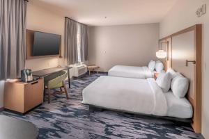 Fairfield Inn & Suites Fort Worth Northeast في هورست: غرفة فندقية بسريرين ومكتب