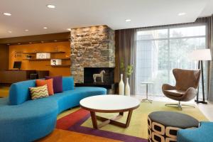 sala de estar con sofá azul y chimenea en Fairfield Inn & Suites by Marriott Lancaster East at The Outlets, en Lancaster