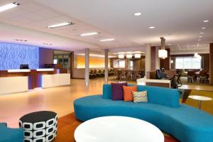 un vestíbulo de oficina con un sofá azul y mesas en Fairfield Inn & Suites by Marriott Lancaster East at The Outlets, en Lancaster