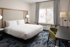 una camera d'albergo con un grande letto e una scrivania di Fairfield Inn & Suites Louisville New Albany IN a New Albany