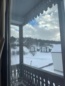 una finestra con vista su un cortile coperto di neve di Travel Inn Bakuriani a Bakuriani