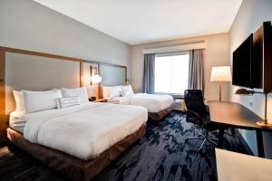 a hotel room with two beds and a desk at Fairfield Inn & Suites by Marriott Plymouth in Plymouth