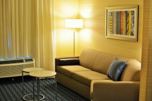 ein Wohnzimmer mit einem Sofa in einem Hotelzimmer in der Unterkunft Fairfield Inn & Suites by Marriott Omaha Northwest in Omaha