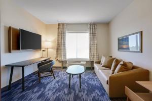 Pokój hotelowy z kanapą, stołem i biurkiem w obiekcie Fairfield Inn & Suites Bardstown w mieście Bardstown