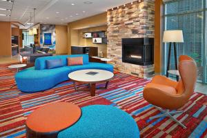 ein Wohnzimmer mit einem blauen Sofa und einem Kamin in der Unterkunft Fairfield Inn & Suites by Marriott St. John's Newfoundland in St. John's