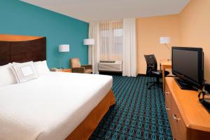 a hotel room with a bed and a flat screen tv at Fairfield Inn & Suites by Marriott Albuquerque Airport in Albuquerque