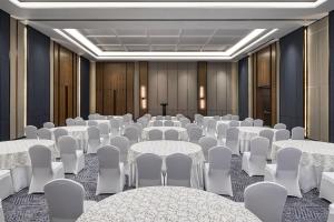 une salle de conférence avec des tables et des chaises blanches dans l'établissement Fairfield by Marriott Goa Benaulim, à Benaulim