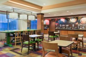 un restaurant avec des tables et des chaises ainsi qu'un bar dans l'établissement Fairfield Inn & Suites by Marriott Springdale, à Springdale