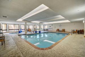 - une grande piscine dans un hôtel avec des chaises et des tables dans l'établissement Fairfield Inn & Suites by Marriott Springdale, à Springdale