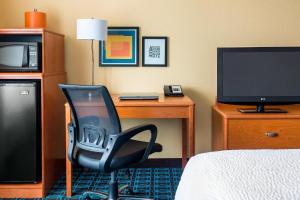 Habitación con escritorio, silla y TV. en Fairfield Inn Muncie, en Muncie