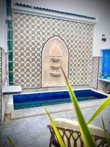 a bathroom with a swimming pool with a tile wall at Dar Saida in Sidi Bou Saïd