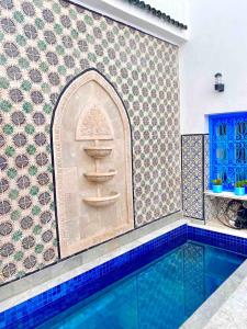 a bathroom with a swimming pool and a tile wall at Dar Saida in Sidi Bou Saïd