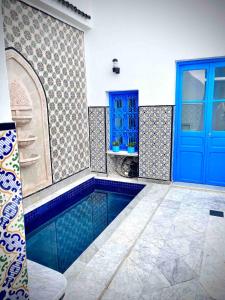 a swimming pool in a room with a blue door at Dar Saida in Sidi Bou Saïd