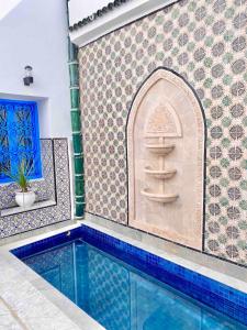 a swimming pool in a room with a tile wall at Dar Saida in Sidi Bou Saïd