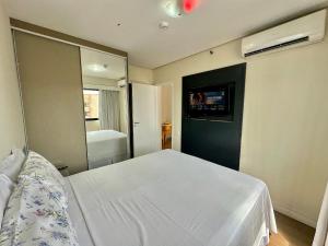 - une chambre avec un lit blanc et un miroir dans l'établissement The Palace TV Giratória Limpeza Diária UH1303, à São Paulo