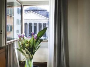 a vase of flowers sitting on a table in front of a window at La Residenza del Sole al Pantheon in Rome