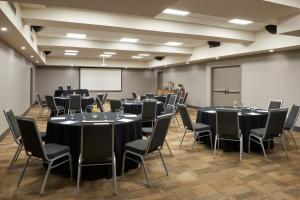 una sala de conferencias con mesas, sillas y una pizarra en Four Points by Sheraton Windsor Downtown, en Windsor