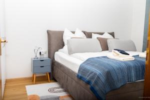 a bed with white pillows and a blue blanket at Taros Home - Deluxe Apartment in Herrenberg