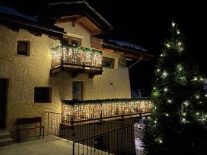 un bâtiment avec des lumières de Noël et un arbre de Noël dans l'établissement Montaz Suite and Sauna, à Valtournenche