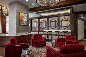 a waiting room with red chairs and a bar at Fairfield Inn & Suites by Marriott Washington Downtown in Washington