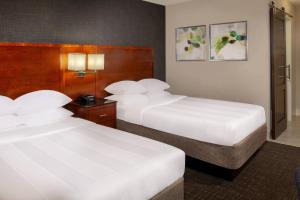 2 Betten in einem Hotelzimmer mit weißer Bettwäsche in der Unterkunft Marriott Raleigh Durham Research Triangle Park in Durham