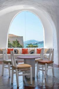 ポルト・チェルボにあるHotel Cala di Volpe, a Luxury Collection Hotel, Costa Smeraldaのテーブル、椅子、ソファが備わる客室です。