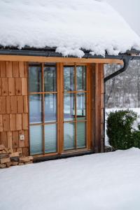 a house with snow on top of its windows at ALPIK Chalets - Bohinj in Bohinj