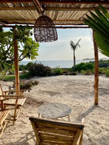 - une table et des chaises sur une plage donnant sur l'océan dans l'établissement Nuru Room at Lulu Beach, à Watamu