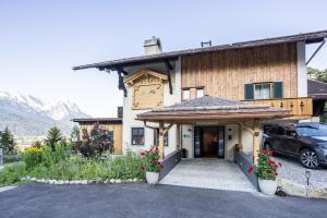 una casa con una macchina parcheggiata di fronte di Landhotel Panorama a Garmisch-Partenkirchen