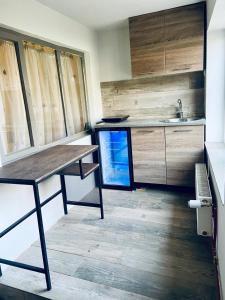 cocina con mesa de madera y fregadero en Apartament 3 Closca, en Floreşti