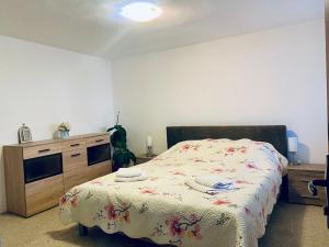 1 dormitorio con 1 cama con colcha de flores y armario en Apartament 3 Closca, en Floreşti