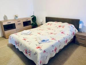 1 dormitorio con 1 cama con colcha de flores en Apartament 3 Closca, en Floreşti