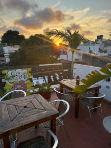 d'une terrasse avec des tables et des chaises et un coucher de soleil. dans l'établissement Pachamama Hostel Cartagena, à Carthagène des Indes