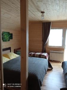 een slaapkamer met 2 bedden in een houten hut bij Nota Bene Mykulychyn in Mykulychyn